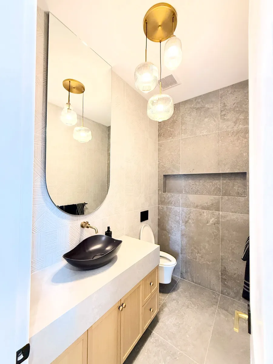 Finished powder room detail with custom vanity, vessel sink and pendant lighting