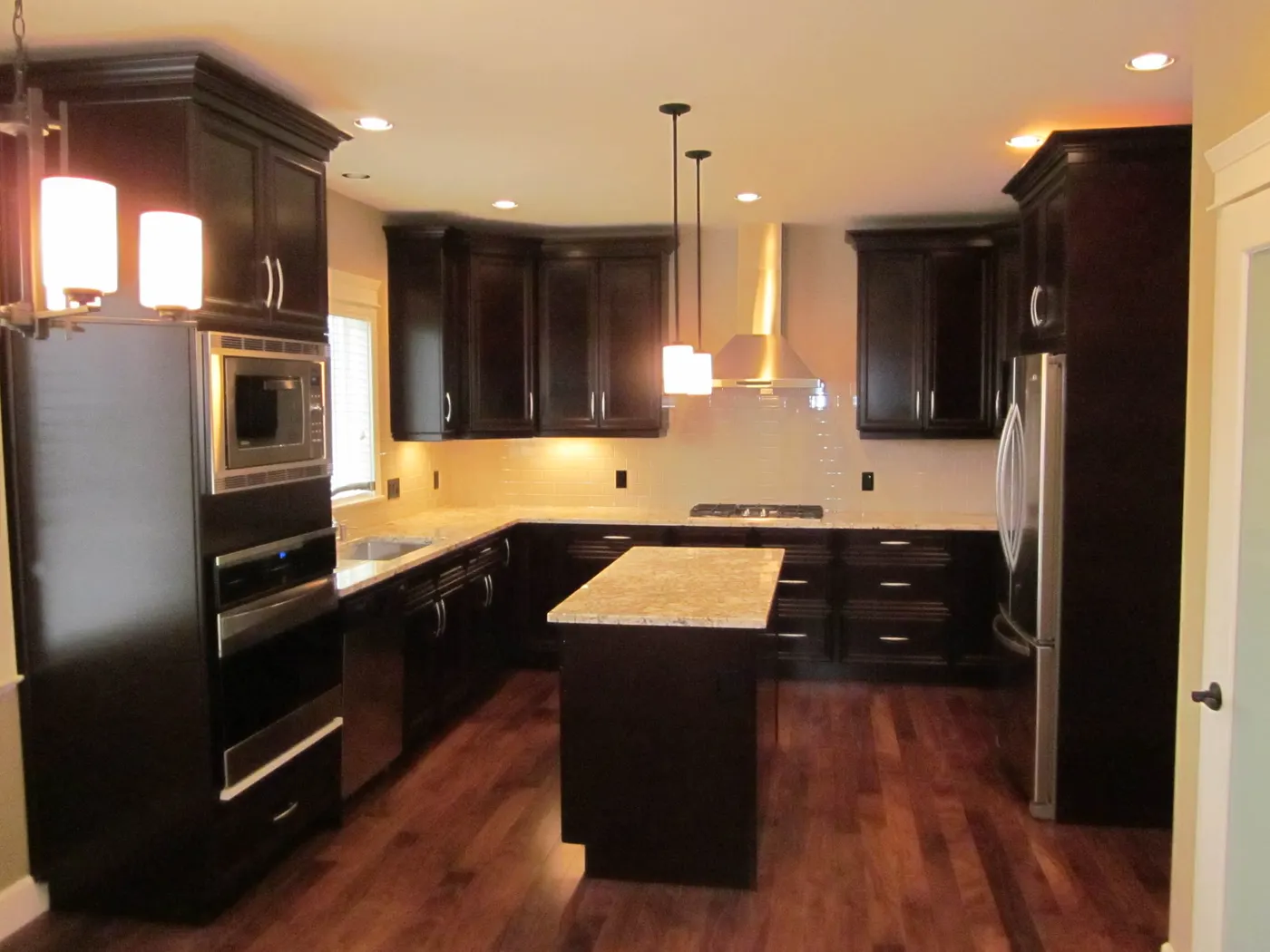Custom kitchen with full-height dark cabinetry and stone island