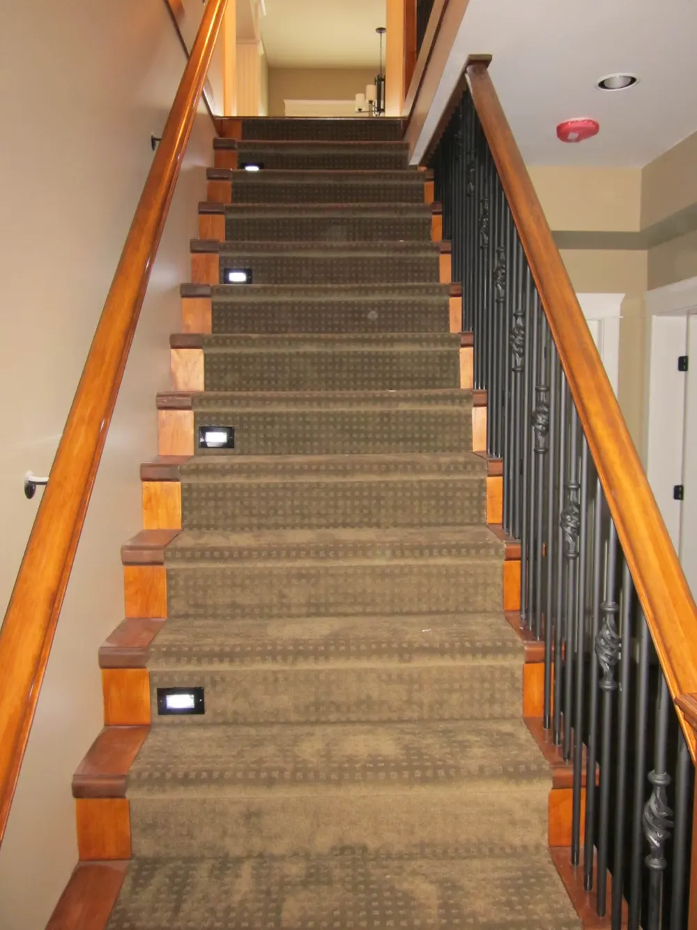 Custom staircase with dark hardwood treads and craftsman railing detail